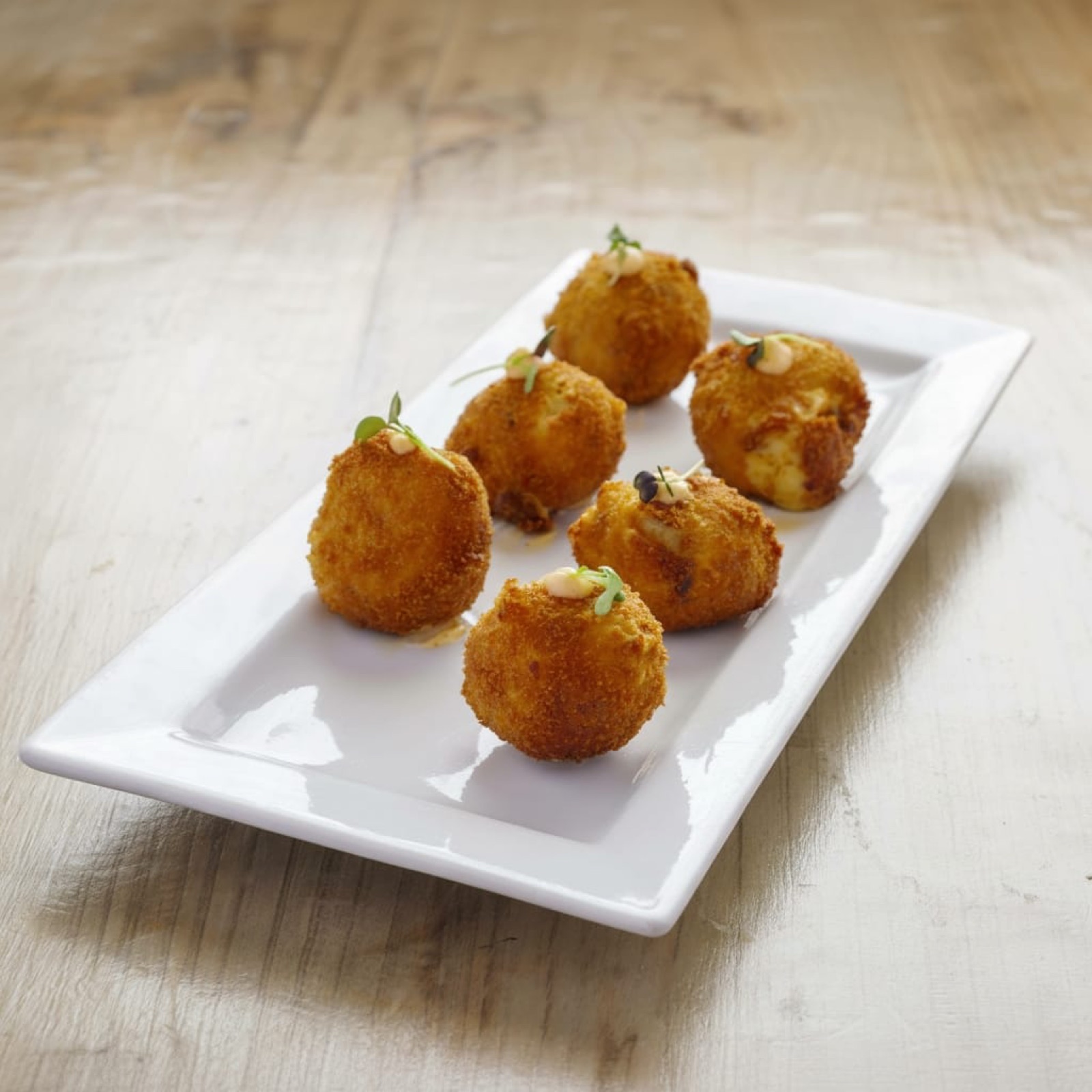 Croquetas artesanas sobre plato blanco
